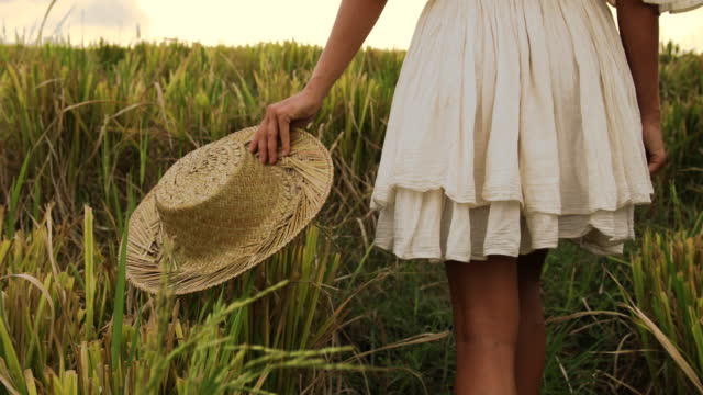 donna-spensierata-con-cappello-di-paglia-che-cammina-nel-campo-di-riso.jpg