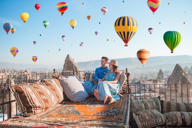 happy-young-couple-during-sunrise-watching-hot-air-balloons-cappadocia-turkey_109800-19089.jpg