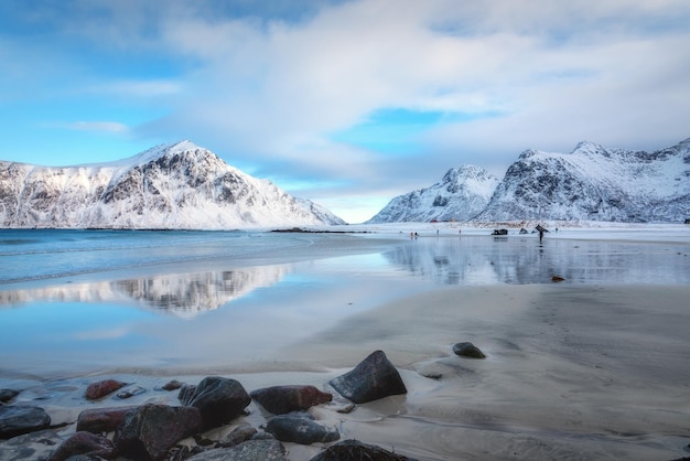 snowy-mountains-blue-sky-with-clouds-reflected-water-winter-arctic-sandy-beach-lofoten-islands-norway-landscape-with-rocks-sea-people-cloudy-day-nature-background-nordic-coast_939522-1908.jpg
